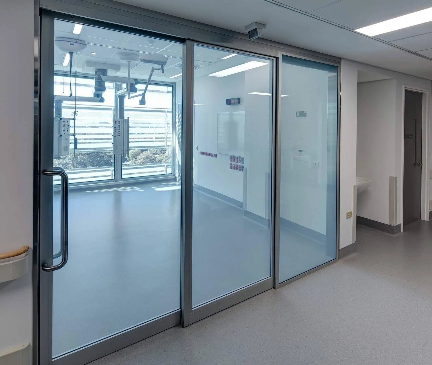 Hospital corridor partition in its clear state, the treatment room and its window visible through the glass